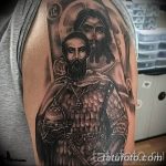 Фото тату Святого Георгия Победоносца и Иисуса Христа на плече, выполненное в черно-серых тонах. Изображение отличается высокой детализацией и реалистичным стилем.