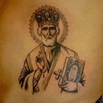 Фото тату святого в иконописном стиле, выполненное в черно-серых тонах. Изображение размещено на груди и отличается традиционной иконографией.