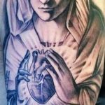 Фото тату на руке с изображением Мадонны, держащей в руках череп. Религиозная тематика, реалистичный стиль, контрастные цвета, символизм жизни и смерти.