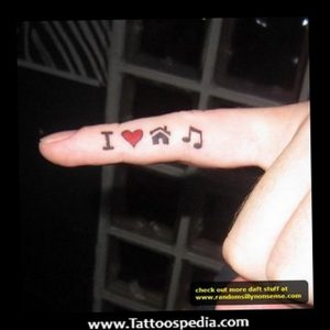Фото тату на пальце: надпись 'I ❤️ ♫'. Небольшой и простой рисунок татуировки в черном цвете.