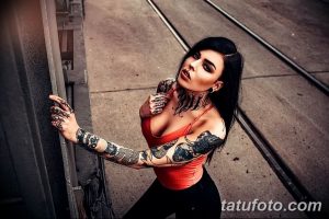 Фото тату на теле девушки: рукава, шея и ключица покрыты детализированными черными татуировками в стиле реализм и графика.