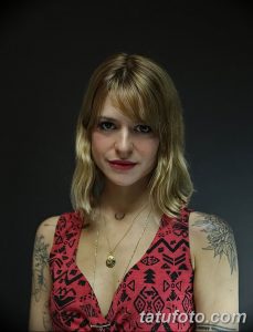 Фото тату: девушка с татуировками на руках и плечах. Яркий стиль, цветочные мотивы, портретная фотография.