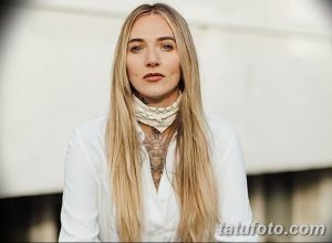 Фото девушки с длинными светлыми волосами и татуировкой на шее. Элегантный образ и пример женственной татуировки.