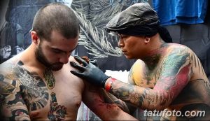 Фото японского мастера тату, делающего татуировку на груди клиента. Видны инструменты и детали рисунка.