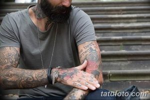 Фото тату на руках мужчины с бородой. Рукава полностью покрыты сложными узорами и рисунками в черных тонах.