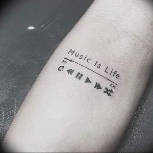 Фото тату на руке: минималистичное изображение музыкального плеера с надписью 'Music Is Life'. Простой и лаконичный рисунок татуировки.