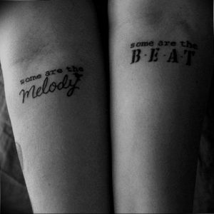 Фото татуировки с надписью "some are the melody, some are the beat" на предплечьях. Простой, но значимый рисунок в черно-белых тонах.