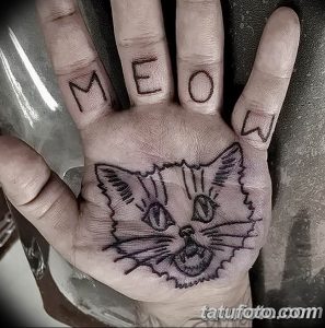 Фото тату с изображением кошачьей мордочки и надписью 'MEOW' на пальцах руки. Черно-белый рисунок татуировки в минималистичном стиле.