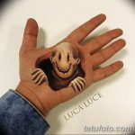 Фото тату: Реалистичная 3D татуировка клоуна, вылезающего из ладони. Уникальный и впечатляющий рисунок татуировки, создающий иллюзию объема.
