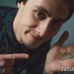 Фотография татуировки с надписью на ладони руки. Черная надпись на неизвестном языке, выполненная четким шрифтом.