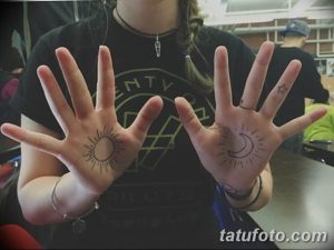 Фото парных тату на ладонях: солнце на одной руке и луна на другой. Черно-белые рисунки в минималистичном стиле, символизирующие дуальность и гармонию.
