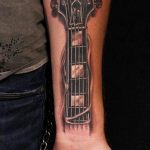 Фото тату: гитара Gibson, татуировка на руке, реализм, черный и серый рисунок, музыкальный инструмент, эскиз тату.