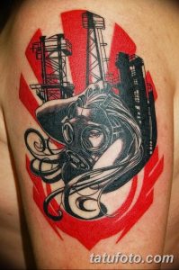 Фото татуировки в стиле dark art с изображением девушки в противогазе на фоне индустриального пейзажа.