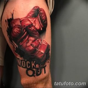 Фото тату боксерских перчаток с надписью "Knock Out", выполненное в реалистичном стиле с использованием ярких цветов и теней.