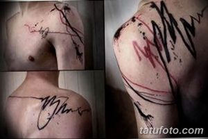 Фото тату на плече с изображением абстрактных линий и мазков в красном и черном цветах, выполненное в минималистичном стиле.