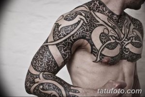Фото тату: масштабная черная татуировка в кельтском стиле, покрывающая грудь, плечи и руки мужчины. Сложные узоры и стилизованные изображения.