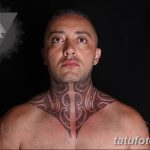 Фото татуировки в стиле трайбл на шее и груди мужчины. Черный рисунок с геометрическими формами и острыми углами. Мужественный и впечатляющий дизайн.