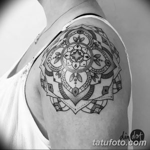 Фото тату мандалы на плече. Черно-белый рисунок в технике dotwork с геометрическими узорами и точками.