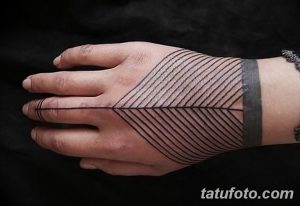 Фото татуировки на руке, выполненной в стиле геометрии. Черно-белый рисунок с использованием диагональных линий и треугольников.