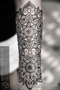 Фото тату мандалы на предплечье, выполненной в технике dotwork. Черно-белый рисунок с множеством точек, создающих сложный узор.