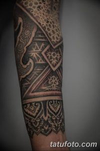 Фото татуировки на предплечье в стиле blackwork. Черно-белые геометрические фигуры и узоры.
