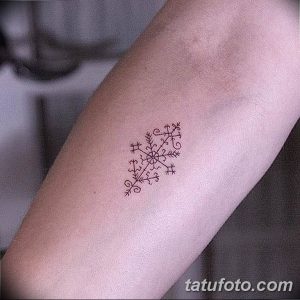 Небольшая черно-белая татуировка в виде снежинки, расположенная на руке. Простой и элегантный дизайн, идеально подходящий для любителей зимы и минимализма.