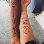 Фото парных татуировок на предплечьях, выполненных в минималистичном геометрическом стиле. Тонкие линии и абстрактные символы.