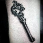 Фото тату на руке: старинный ключ с витиеватым узором, выполненный в технике blackwork.