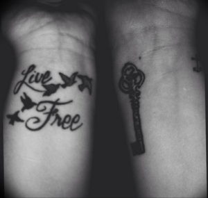 Фото тату: парная татуировка на запястьях - ключ и надпись 'Live Free' с изображением летящих птиц. Символ свободы и независимости.
