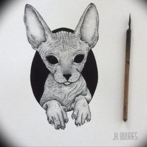 Черно-белое фото тату сфинкса, выполненного в технике pointillism. Детализированный рисунок кошачьей морды на белом фоне.