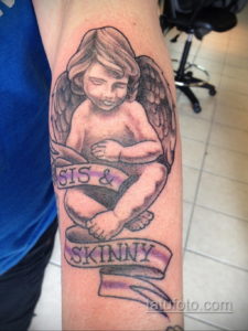 Фото тату на руке: ангел с опущенной головой и сложенными в молитве руками, под ним надпись 'Sis & Skinny'.
