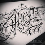Черно-белый эскиз татуировки с надписью 'Hustle', выполненный в сложном леттеринге с декоративными элементами и тенями.