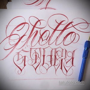 Эскиз татуировки с надписью 'Ghetto World', выполненный в красном цвете в стиле леттеринга с декоративными элементами и тенями.