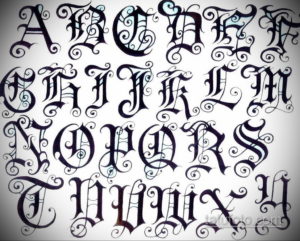 Sheet of Old English alphabet letters with intricate swirls and flourishes. Black ink on paper, showcasing a detailed tattoo font style.