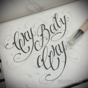 Black and grey calligraphy tattoo featuring the phrase 'Cry Baby' in a flowing, elegant script with delicate swirls and flourishes.