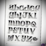 Черно-белый эскиз татуировки с изображением латинского алфавита в стиле олд скул, выполненный четкими линиями и затененными буквами.