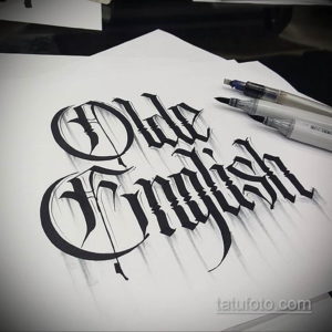 Эскиз надписи 'Old English', выполненный в готическом стиле. Черные чернила на белой бумаге, демонстрирующие детализированную каллиграфию.