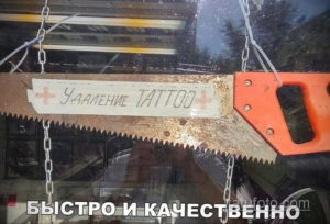 Фотография ржавой пилы с надписью 'УДАЛЕНИЕ TATTOO' на лезвии. Ироничное изображение, высмеивающее грубые и опасные методы удаления татуировок.
