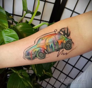 Фото акварельной татуировки на руке с изображением винтажного автомобиля Volkswagen. Изображение демонстрирует красочный и детализированный рисунок татуировки.