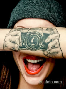 Фото тату на руке: реалистичное изображение камеры Pentax, словно держащейся в руках, черно-белый рисунок.