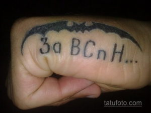 Фото тату на руке: стилизованное изображение летучей мыши с надписью 'За ВСнН'. Черно-белый рисунок татуировки выполнен в минималистичном стиле.