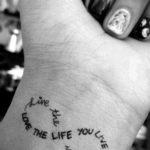 Фото тату: Надпись "Live the life you love" в виде браслета на запястье. Мотивационная татуировка с красивым шрифтом.