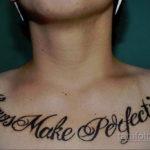 Фото тату с надписью 'Flaws Make Perfection' на шее. Черный контур, каллиграфический шрифт, изогнутая линия. Стильная и мотивирующая татуировка.