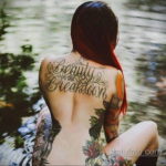Фото тату с надписью 'Beauty in the Breakdown' на спине. Каллиграфия, яркие цвета, цветочные элементы. Идеи для тату на спине.