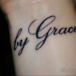 Фото тату с надписью "by Grace", выполненной элегантным каллиграфическим шрифтом на женском запястье.