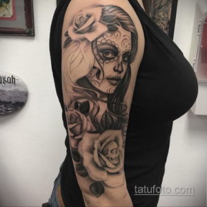 Фото тату: большая черно-белая татуировка в стиле сахарной черепушки (calavera) с розами на руке, выполненная с высокой детализацией.