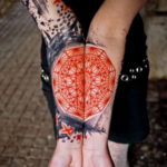 Фото тату Flower of Life на запястьях. Красный геометрический узор, симметричный дизайн, минималистичный стиль.
