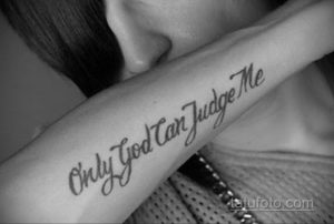 Фото тату: черная надпись 'Only God Can Judge Me' на предплечье. Эскиз татуировки выполнен каллиграфическим шрифтом.