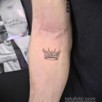 Фото минималистичной татуировки в виде короны на руке. Тонкие линии и простой дизайн делают эту тату элегантной и стильной.