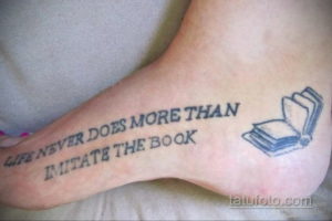 Фотография татуировки на стопе с цитатой 'Life never does more than imitate the book' и изображением открытой книги.